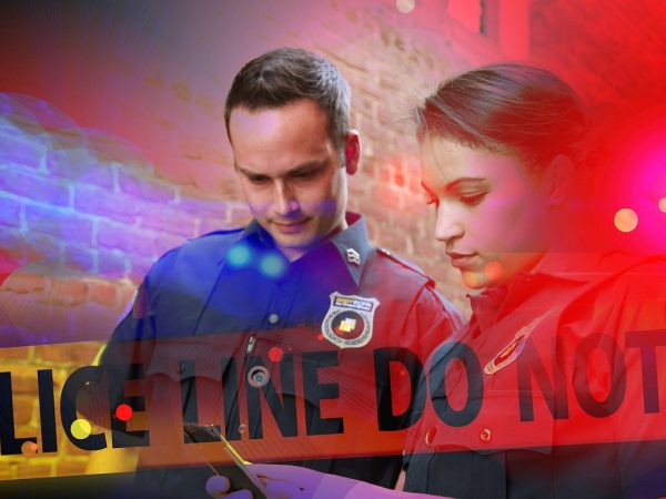 警察记录案件信息场景，笔记本与录音设备摆放在警务台上，呈现正规报案接待流程